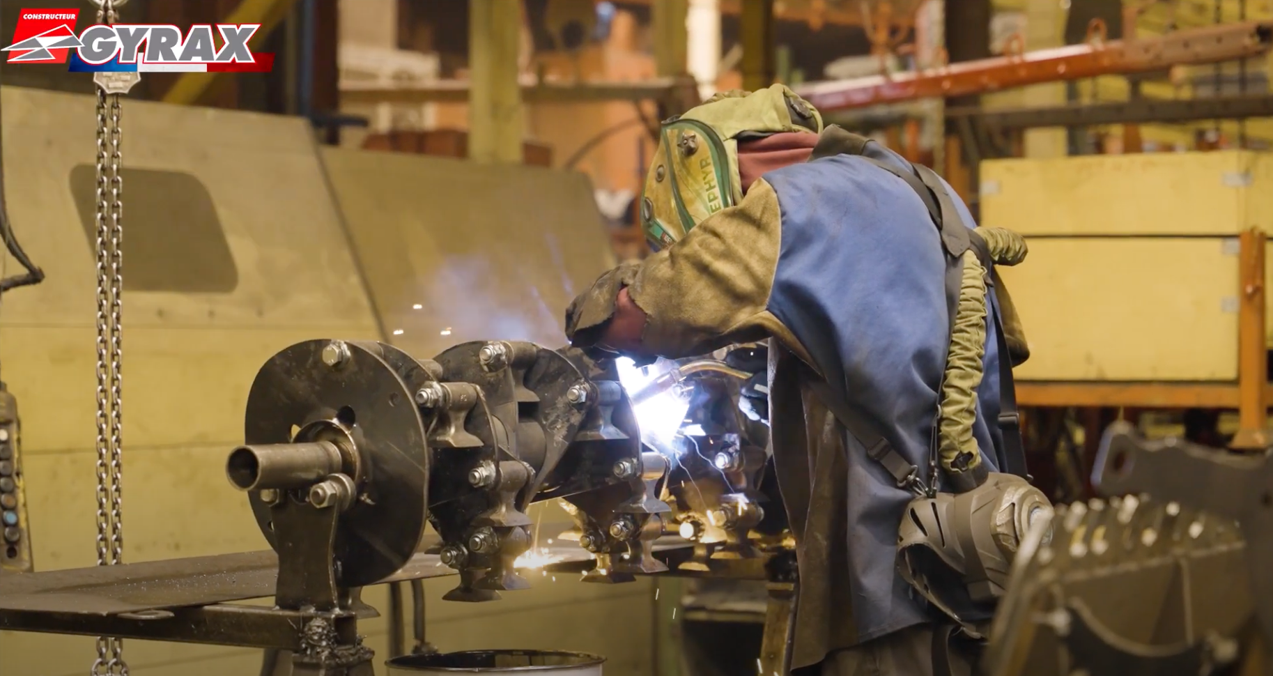 Soudeur au travail en train de souder une pièce, dans les usines Gyrax