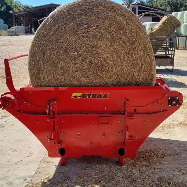 Dérouleuse de bottes à paille rouge de marque gyrax, chargée