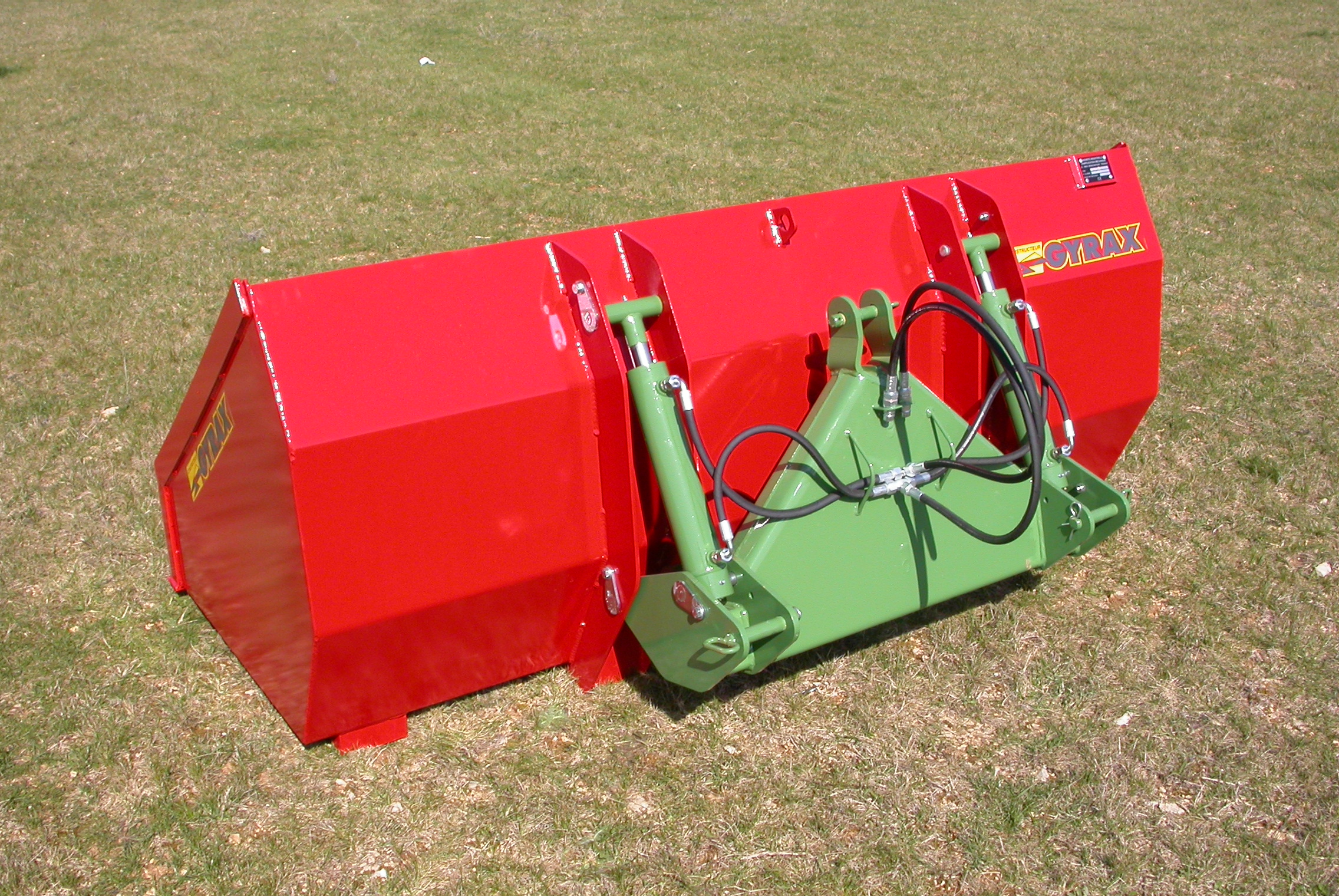 Godet Hydraulique 3 points posé au sol de dos.