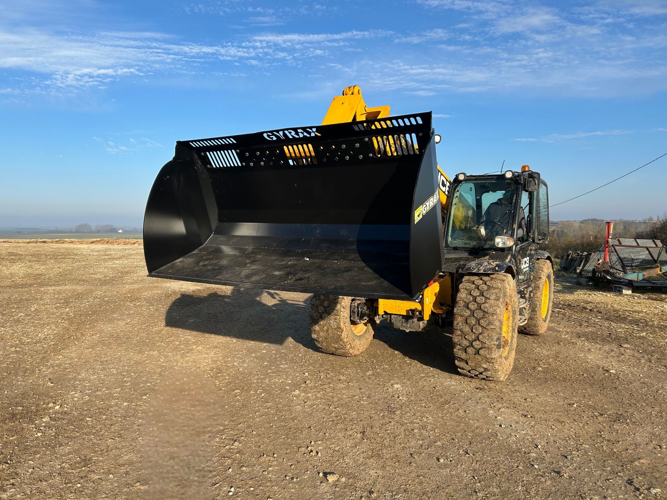 Godet terre noir Gyrax attelé sur un telescopique pret à etre utilisé