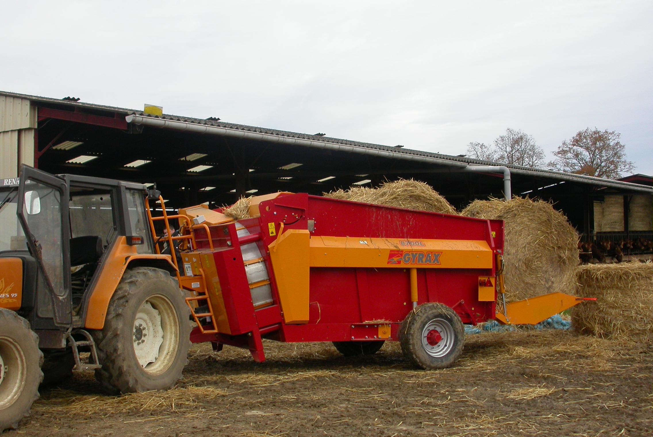Pailleuse rouge de marque gyrax modele 8700 en action dans une ferme