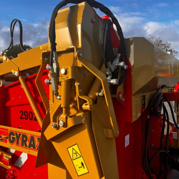 Goulotte de distribution d'une désileuse pailleuse portée rouge et or de marque Gyrax, modèle 2902.