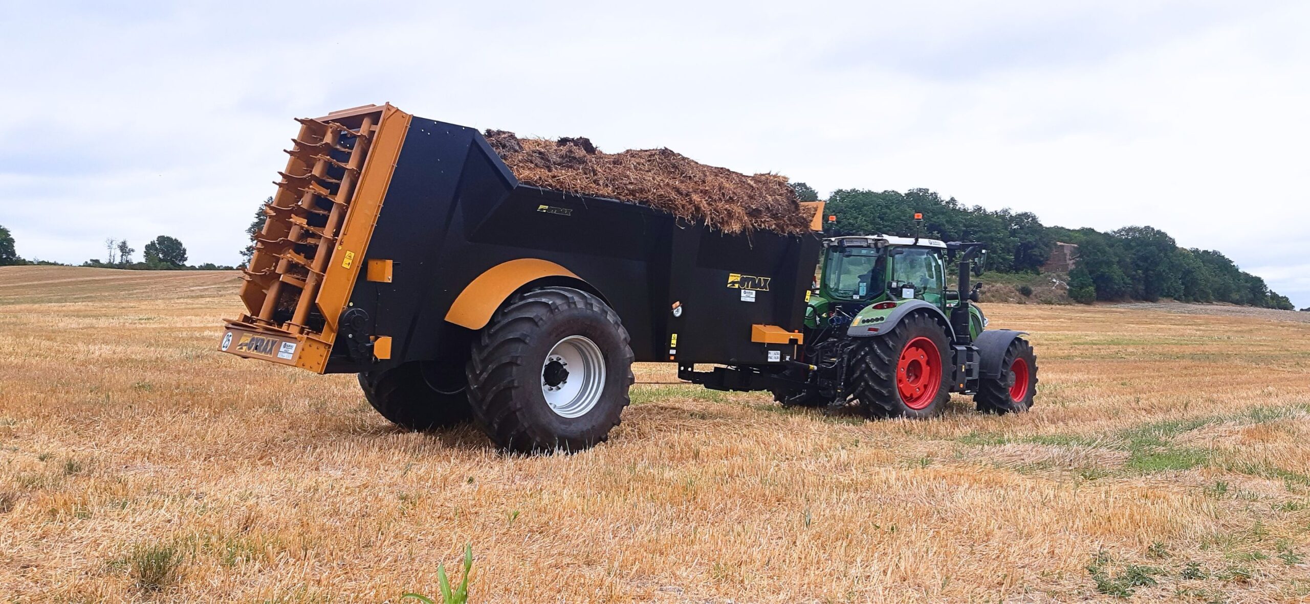 Epandeur EDHV 190 noir et jaune, marque Gyrax, dans un champs, repli prêt à épandre.
