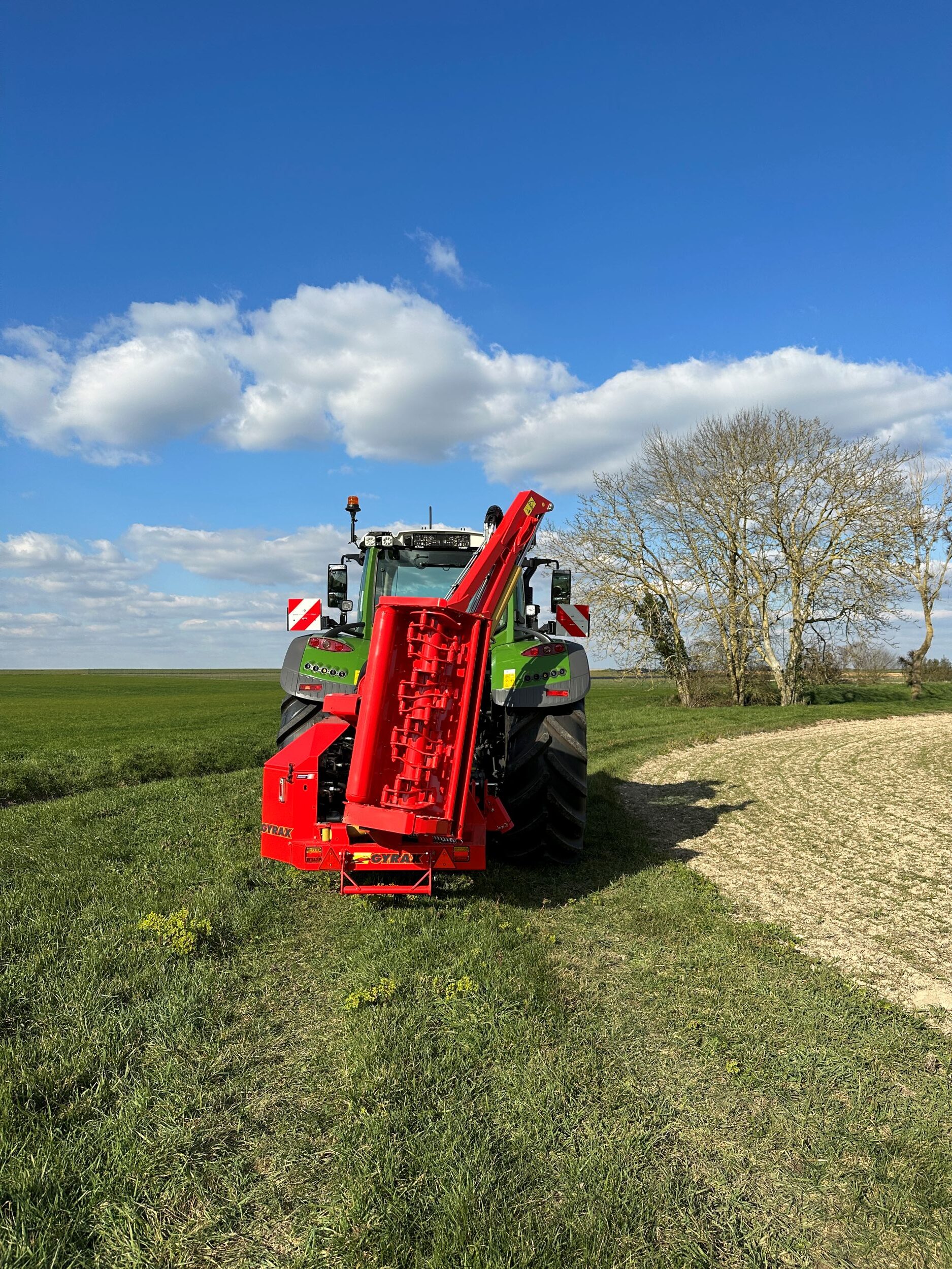 Epareuse 1251 gamme agricole GYRAX, repliée derrière un tracteur.