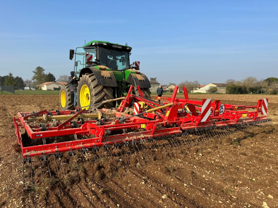 Vibroculteur Gyrax rouge, au milieu d'un champs, vu au sol arrière