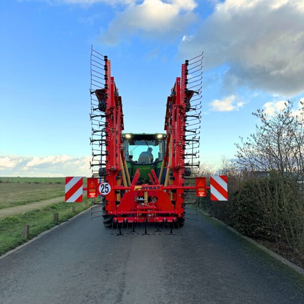Vibrocuteur Gyrax rouge, transporté replié sur une petite route.