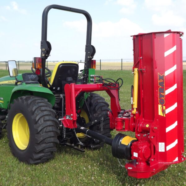Roto-faucheuse rouge Gyrax, modèle RFL (loisir), vue 3/4 arrière attelée sur un micro tracteur, au transport dans un champs.