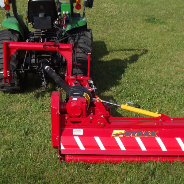 Roto-faucheuse rouge Gyrax, modèle RFL (loisir), vue arrière attelée sur un micro tracteur, en coupe d herbe au sol, position horizontale