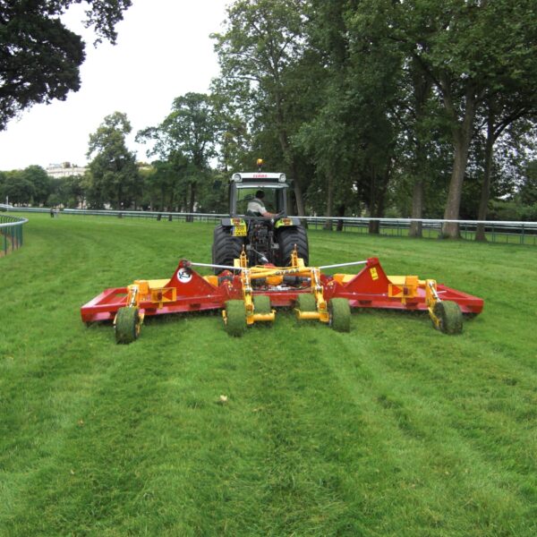 Vue arrière du broyeur prairie repliable GYRAX BHR montrant les rotors à lames, le système de répartition de l’herbe et les roues de suivi de terrain.