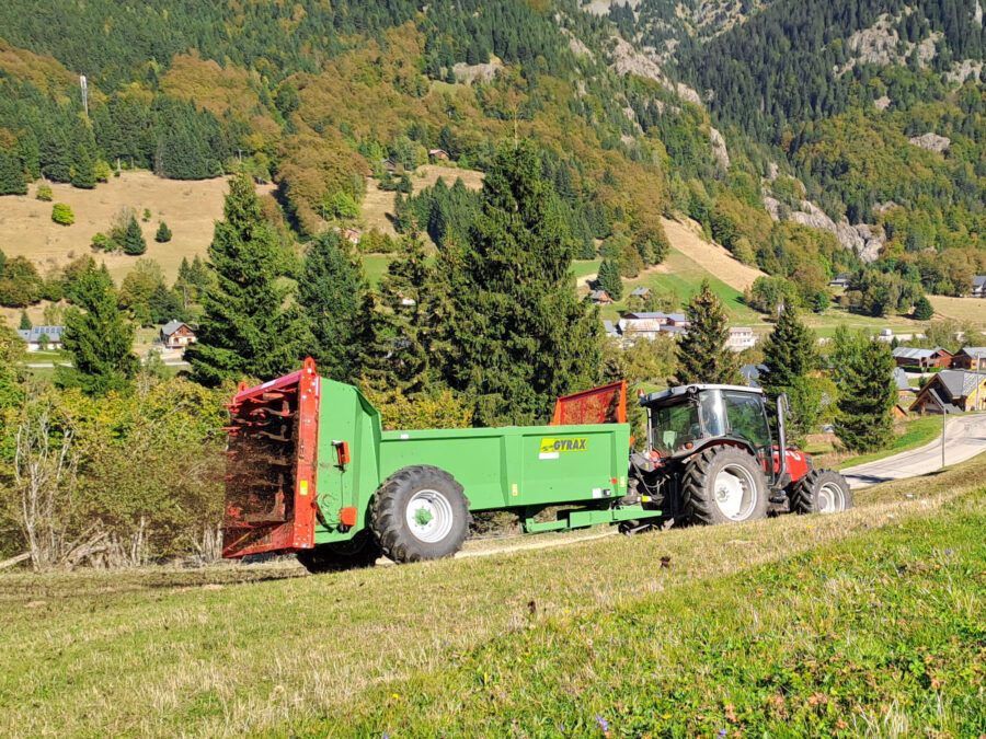 Epandeur à fumier EDHV 65 Gyrax, au milieu d'une vallée en train d'épandre.