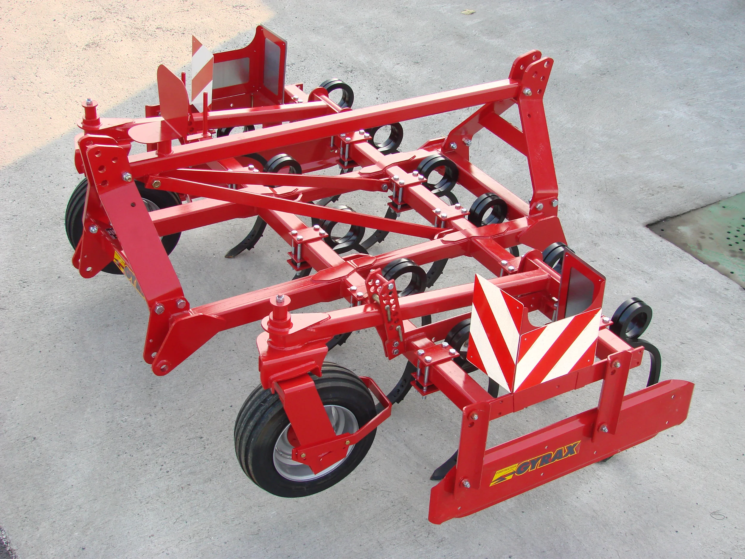 Cultivateur fixe rouge de marque Gyrax, modele, 2 poutres. Au sol sortie d'usine