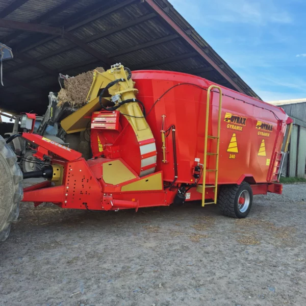 Mélangeuse bivis Gyrax à l'entrée d'un cheptel, en cours de chargement pour distribution via la turbine de paillage orientable.